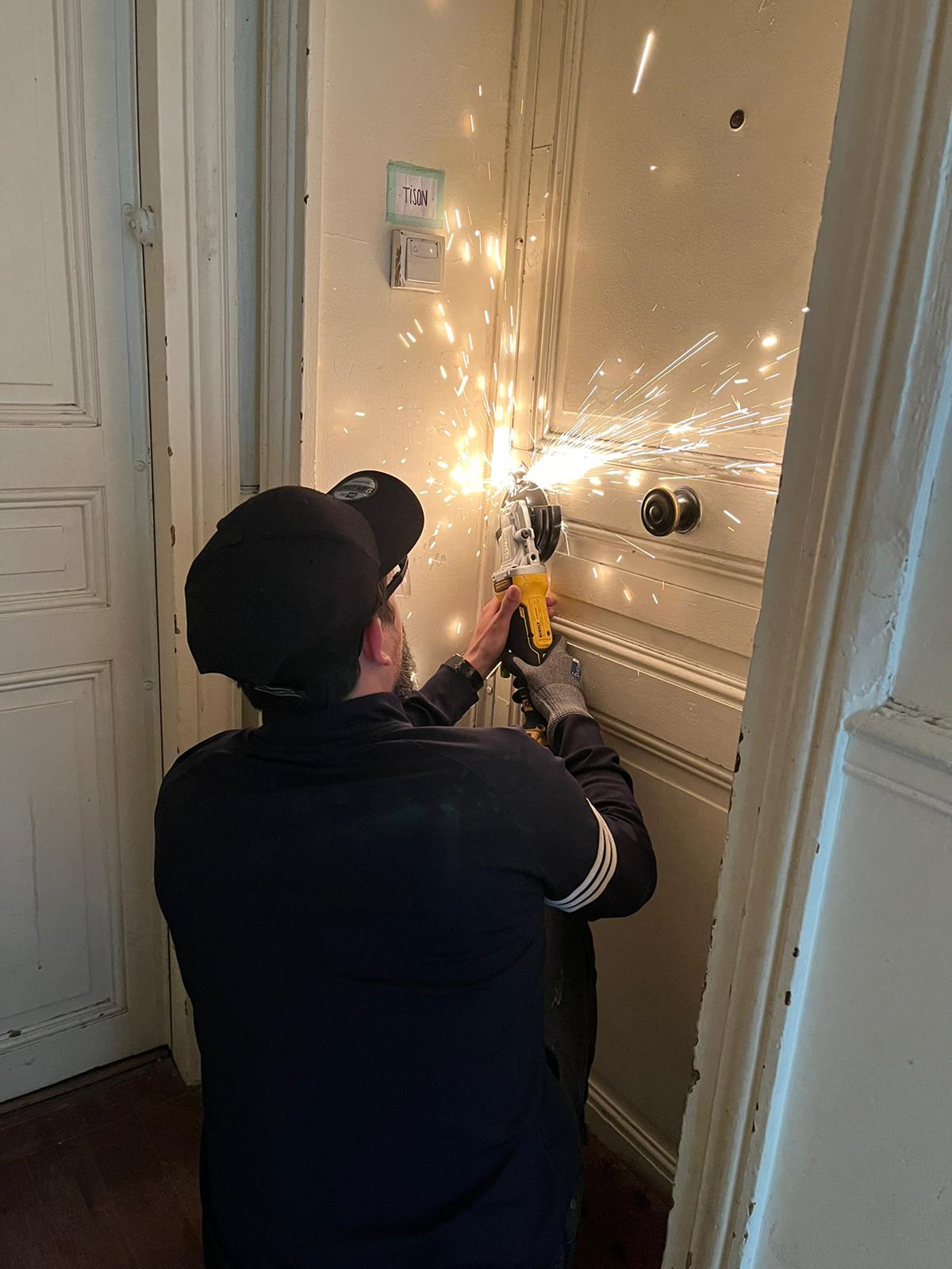 un artisan en train d'ouvrir une porte avec du matériel professionnel.